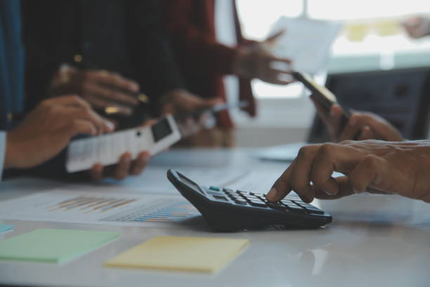 istock Financial analysts analyze business financial reports on a digital tablet planning investment project during a discussion at a meeting of corporate showing the results of their successful teamwork. 1499414311
