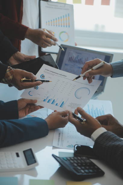 istock Financial analysts analyze business financial reports on a digital tablet planning investment project during a discussion at a meeting of corporate showing the results of their successful teamwork. 1499414338