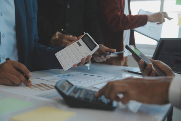 istock Financial analysts analyze business financial reports on a digital tablet planning investment project during a discussion at a meeting of corporate showing the results of their successful teamwork. 1499414341