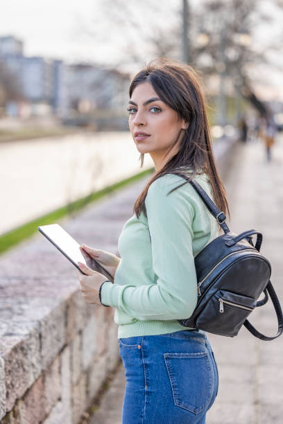 istock Student girl posing with a tablet in her hands near the river 1499416087