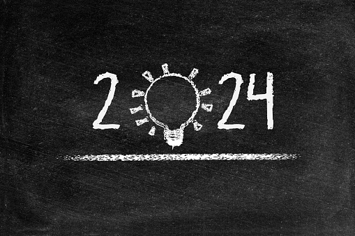 2024 Ideas text in lightbulb for creative idea concept, computer graphic with chalk drawings black board
