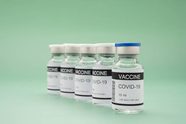 вакцина от covid-19 на зеленом фоне. - covid vaccine стоковые фото и изображения