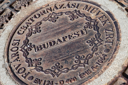 Stylised bronze manhole cover on the pedestrianised high street of Budapest, the capital city of Hungary