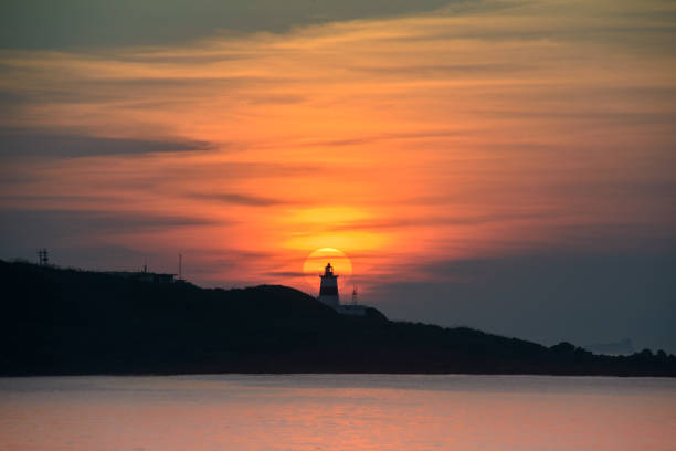 istock At dusk, the sun is behind the lighthouse. 1499420693