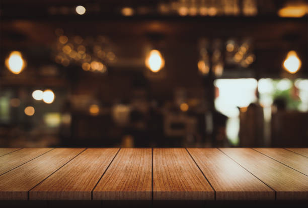 istock Empty wooden table top with lights bokeh on blur restaurant background. 1499423095