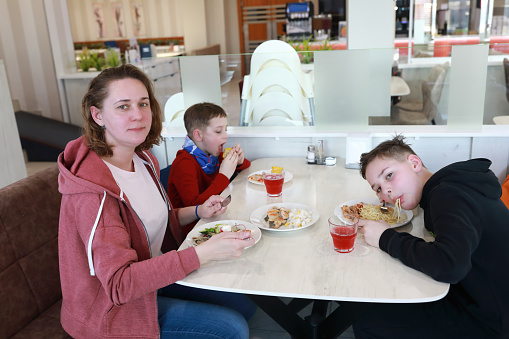 Mother with her sons have lunch in restaurant