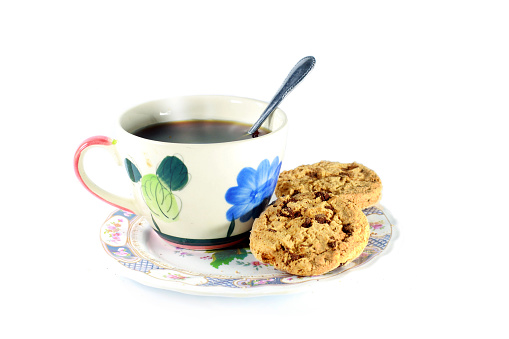 black coffee and cookies stack in dish isolated on white background.