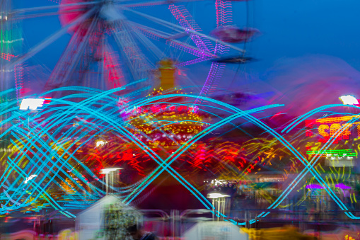 A multi-colored Ferris Wheel lights up the night sky in long exposure.