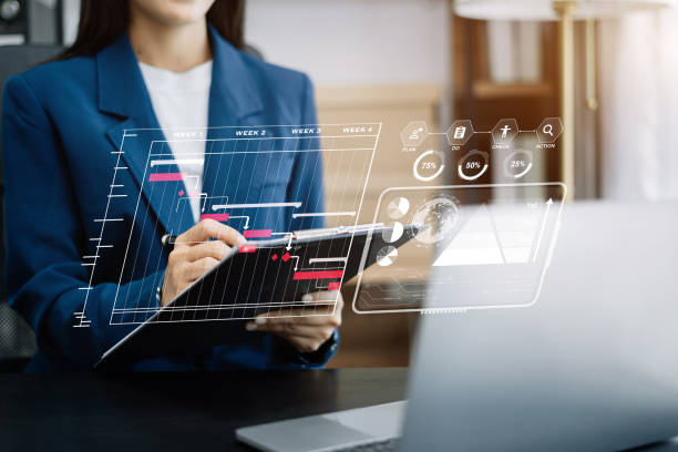 istock Business woman hand Project manager working and update tasks and Gantt chart scheduling virtual diagram.with smart phone, tablet and laptop in office. 1499433455
