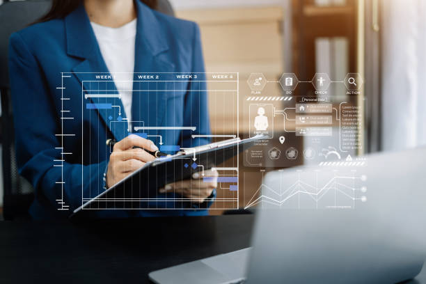 istock Business woman hand Project manager working and update tasks and Gantt chart scheduling virtual diagram.with smart phone, tablet and laptop in office. 1499433462