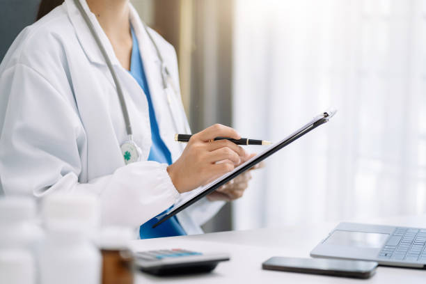 istock female medical doctor's hands write a note and use tablet working. Doctor's working place. Healthcare and medical concept. 1499435299