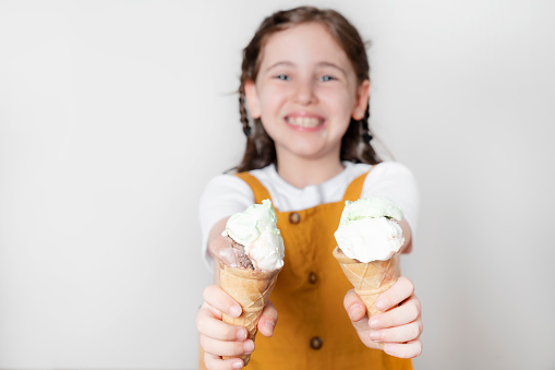 Lovely girl eating ice cream on white