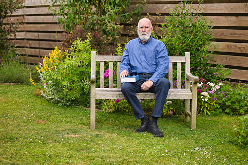 Casually-dressed man in his 70s out in his garden.