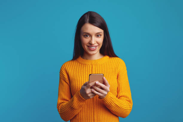 istock Smiling young woman holds modern cellular, sends message in social networks 1499449328