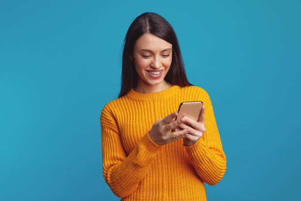 istock Smiling young woman holds modern cellular, sends message in social networks 1499450254