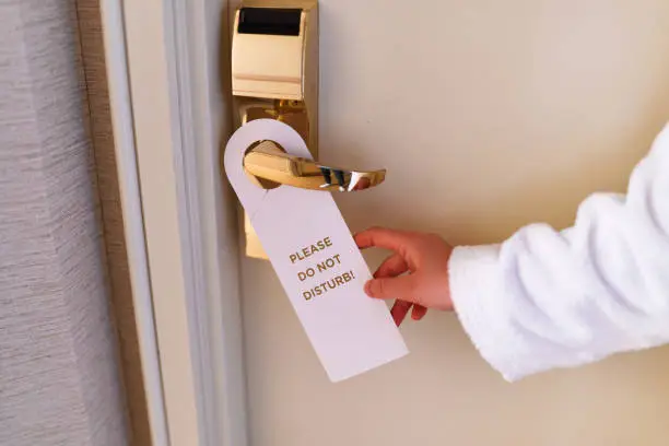 Photo of Do not disturb sign on the doorknob of hotel