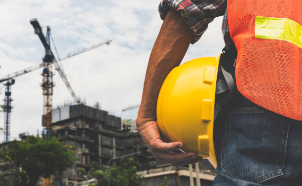 istock The construction engineer is watching the work and holding a yellow safety helmet. 1499454368