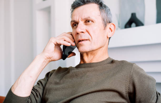 istock Serious concerned old man talking on mobile phone, calling for emergency, ambulance. 1499457485