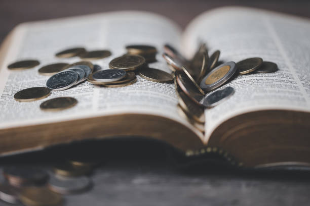 istock One tenth or tithe is basis on which Bible teaches us to donate one tenth of first fruit to God. Coins with Holy Bible. Religion donation and funding. Giving money, the symbol of Christianity donation 1499466820