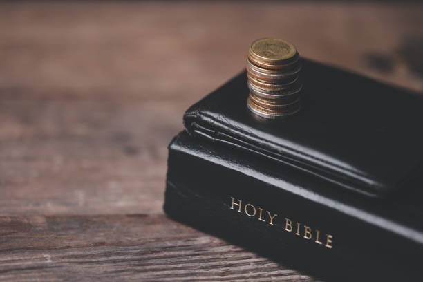 istock One tenth or tithe is basis on which Bible teaches us to donate one tenth of first fruit to God. Coins with Holy Bible. Religion donation and funding. Giving money, the symbol of Christianity donation 1499466846
