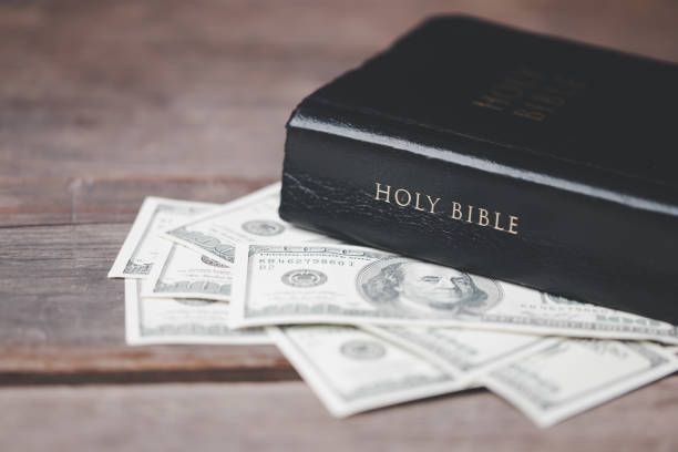 istock One tenth or tithe is basis on which Bible teaches us to donate one tenth of first fruit to God. Coins with Holy Bible. Religion donation and funding. Giving money, the symbol of Christianity donation 1499466910
