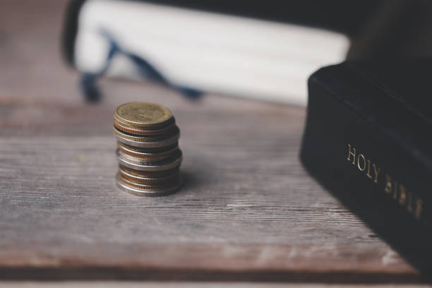 istock One tenth or tithe is basis on which Bible teaches us to donate one tenth of first fruit to God. Coins with Holy Bible. Religion donation and funding. Giving money, the symbol of Christianity donation 1499467063