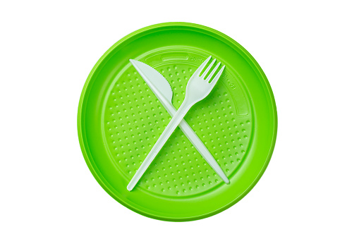 Green plastic plate with fork and knife isolated on white background. file contains clipping path