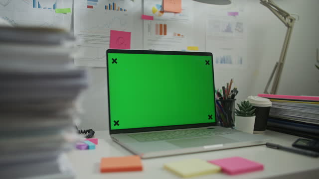 Laptop Computer Monitor with Mock Up Green Screen Chroma Key Display Standing on the Desk in the Modern Business Office