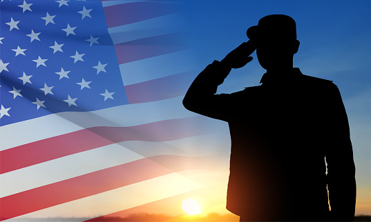 Silhouette of a saluting soldier against the sunset with USA flag. Greeting card for Veterans Day, Memorial Day, Independence Day. EPS10 vector