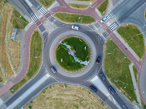 Traffic circle with driving cars from above.