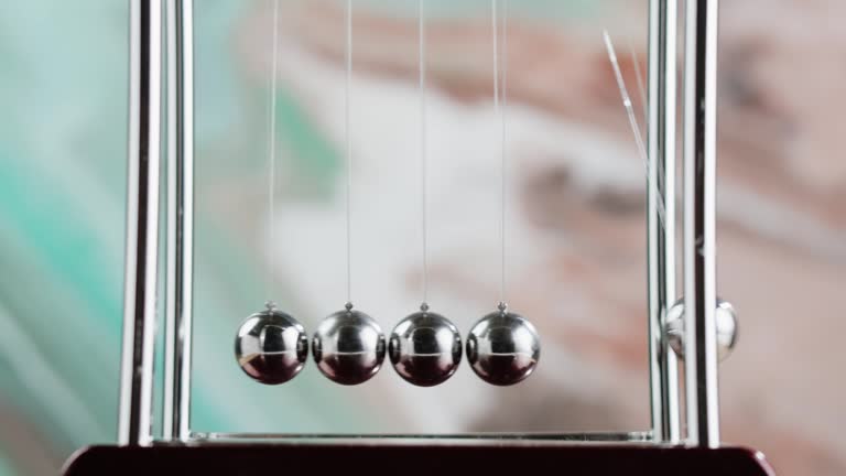 Newton balls close-up, five metallic pendulums colliding, cradle. Physics and science concept.