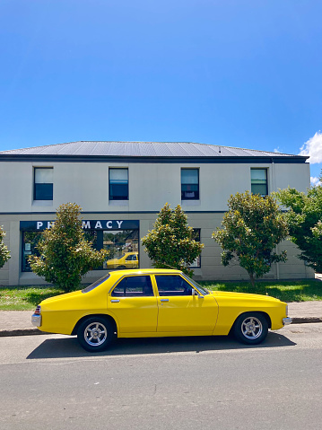 Richmond, Tasmania, Australia - December 28 2022: Yellow vintage Australian classic Holden Kingswood sedan car parked on the historic Richmond street