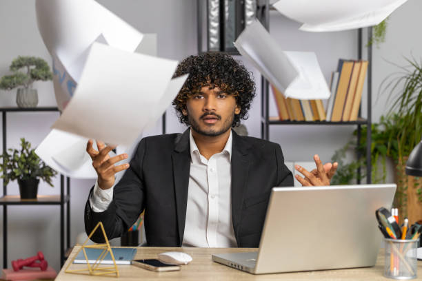 istock Stressed businessman work at unpaid bank debt, doing paperwork, planning budget, throws paper bills 1499483614