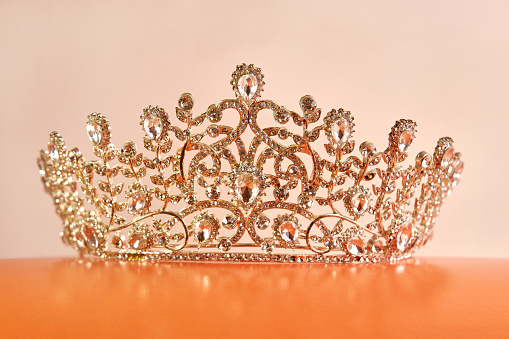 The crown is decorated with stones on an orange stand.