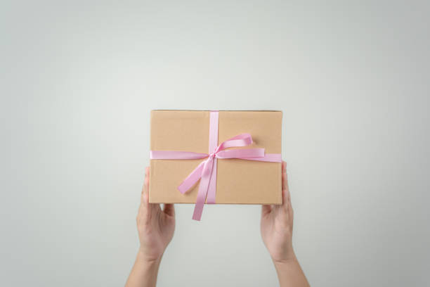 istock Woman hand holding gift box with pink bow ribbon 1499485714