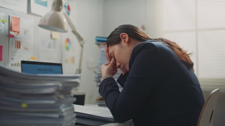 Businesswoman tired and exhausted with a lot of paperwork