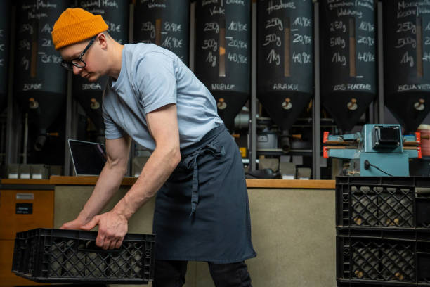 istock Caucasian man coffee shop worker gets new batch of coffee packages in boxes on roasting factory. 1499487594