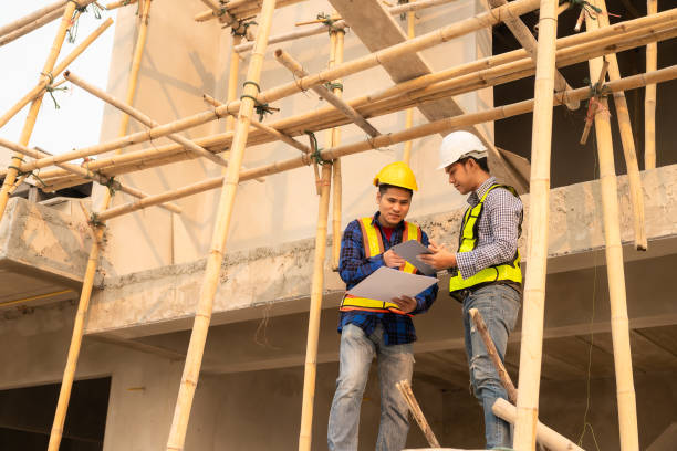 istock Civil engineers inspect work with walkie-talkies for communicating with the management team. Engineer recommends house construction to supervisor at construction site home building ideas 1499487961