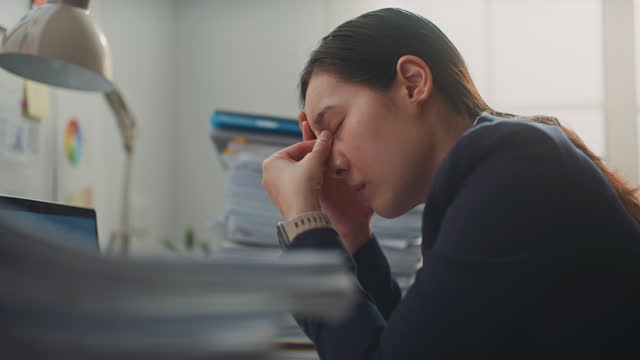 Businesswoman tired and exhausted with a lot of paperwork