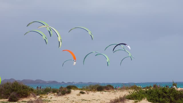 Lots of kites in the sky, preparation for kiteboarding competitions