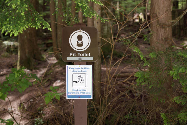Information placards about outhouse, latrine or drop toilet in camp ground or public park. North Vancouver, BC, Canada. Selective focus.
