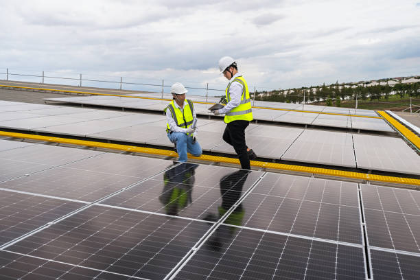 istock Engineer checking installation of solar panels installed on factory roof, checking installation of solar panels. Asian engineer records inspection data on tablet, supervising solar panel installation. 1499492270