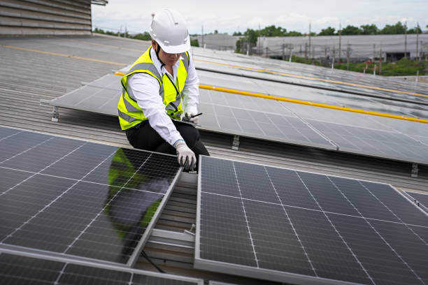 Engineer checking installation of solar panels installed on factory roof, checking installation of solar panels. Asian engineer records inspection data on tablet, supervising solar panel installation. ingeniero de verificación de la instalación de paneles solares instalados en el techo de la fábrica, verificando la instalación de paneles solares. ingeniero asiático registra los datos de inspección en tabletas, supervisando la instalación del pane