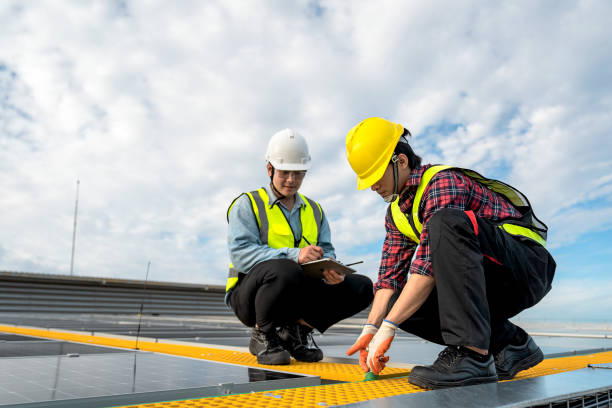 istock Technicians are installing solar panels on factory roof, with Asian engineer supervising, supervising installation. Installation of solar panels to transform solar energy into sustainable electricity. 1499492324