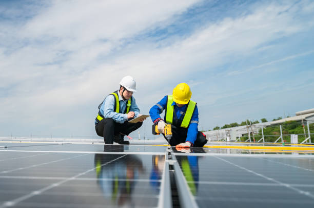istock Technicians are installing solar panels on factory roof, with Asian engineer supervising, supervising installation. Installation of solar panels to transform solar energy into sustainable electricity. 1499492349