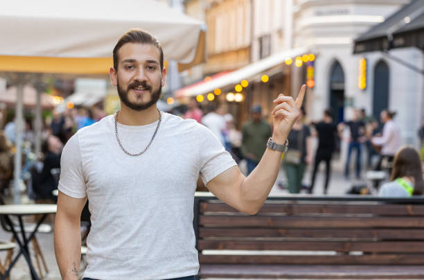 istock Thoughtful man pointing empty place advertising area for commercial text copy-space in city street 1499493202