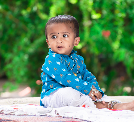 Beautiful little baby, little baby with a happy face and background green. cute Indian baby