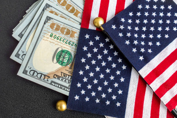 istock American flags with dollar bills on black background. 1499499224