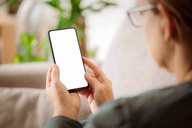 Woman using smartphone at home stock photo