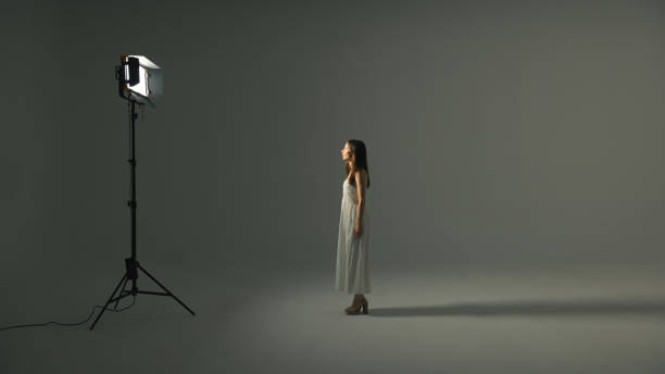 Model posing in the Studio. The girl is photographed in a photo Studio. View of a young woman posing in a photo Studio. Contrast lighting. Brunette posing.